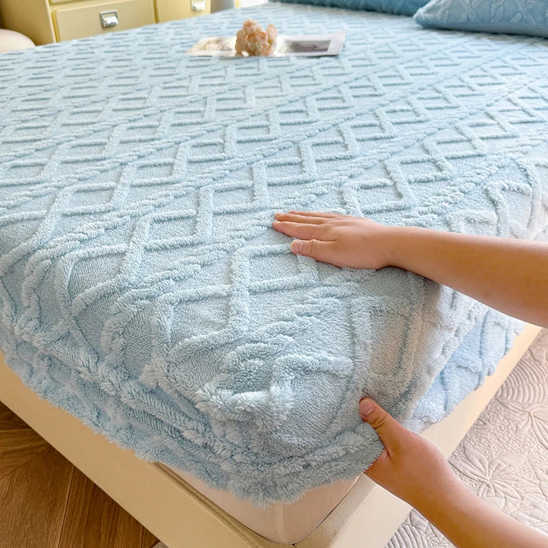 Une couverture douce et confortable avec un motif géométrique bleu élégant, posée sur un lit douillet.