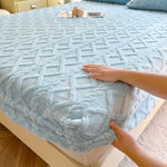 Une couverture douce et confortable avec un motif géométrique bleu élégant, posée sur un lit douillet.