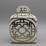 Élégante poterie décorative blanche et dorée avec un motif géométrique abstrait complexe.
