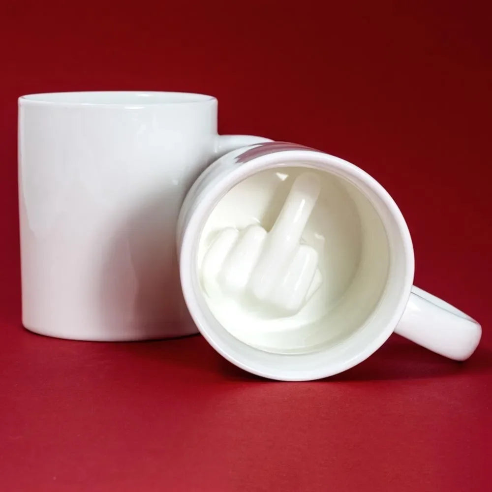 Tasse blanche motif doigt d'honneur sur table en bois