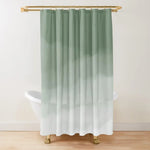 Rideau de douche au design épuré avec un dégradé de vert sauge vers le blanc, créant un effet aquarelle subtil et apaisant. Suspendu à une tringle dorée élégante, il se trouve devant une baignoire sur pieds aux pattes dorées, ajoutant une touche raffinée et moderne à la salle de bain. L’arrière-plan sobre met en valeur l’aspect minimaliste et naturel du rideau, idéal pour une décoration zen et contemporaine.
