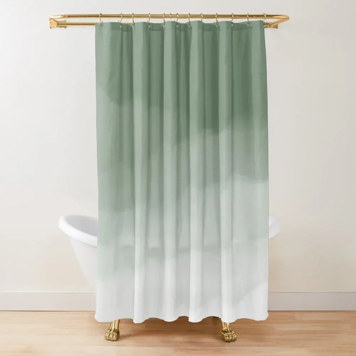 Rideau de douche au design épuré avec un dégradé de vert sauge vers le blanc, créant un effet aquarelle subtil et apaisant. Suspendu à une tringle dorée élégante, il se trouve devant une baignoire sur pieds aux pattes dorées, ajoutant une touche raffinée et moderne à la salle de bain. L’arrière-plan sobre met en valeur l’aspect minimaliste et naturel du rideau, idéal pour une décoration zen et contemporaine.