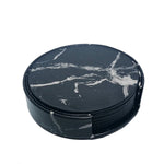 Ensemble de sous-verres ronds en marbre noir avec motifs de veines blanches.
