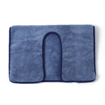 Un tapis de bain bleu marine en tissu éponge doux et moelleux.