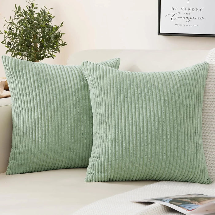 Housse de coussin vert sauge en velours côtelé rayé sur canapé