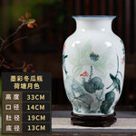 Vase décoratif en porcelaine blanche et grise orné de fleurs et de motifs floraux élégants, sur un socle en bois.
