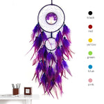 Ce magnifique attrape-rêves de couleur violet possède un joli centre orné d'un arbre de vie et des plumes d'une belle teinte rose et pourpre.