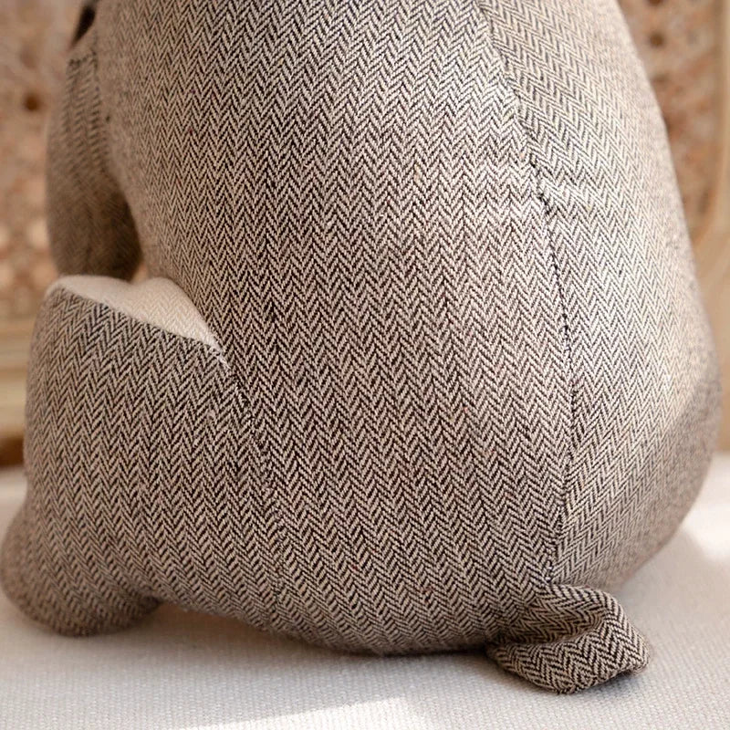Cale-porte lapin en peluche dans un intérieur cosy avec coussins