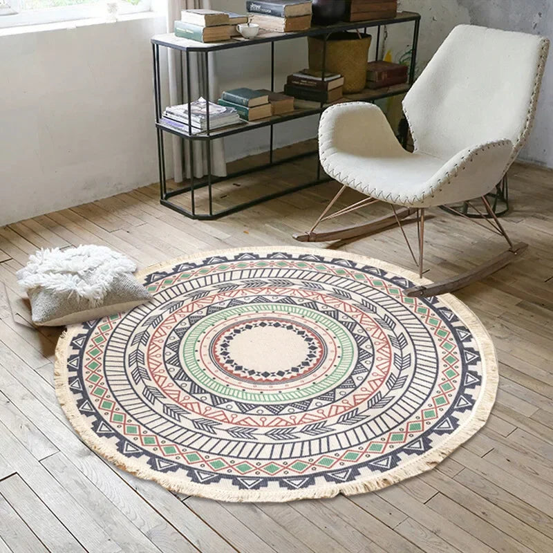 Un tapis rond coloré et motif géométrique oriente l'espace avec un fauteuil rembourré blanc et des étagères remplies de livres.
