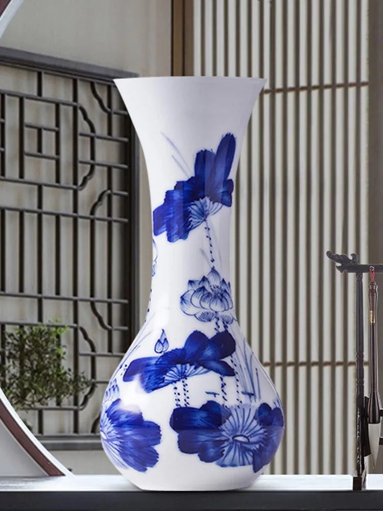 Vase décoratif en porcelaine blanche avec un motif floral bleu élégant et sophistiqué.