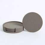 Ensemble de sous-verres ronds en tissu gris foncé avec coutures apparentes.