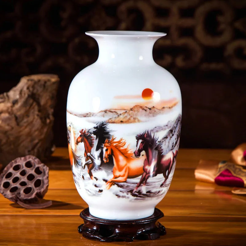 Un vase en porcelaine orné d'une scène magnifique montrant plusieurs chevaux galopant dans un paysage montagneux avec un soleil couchant.