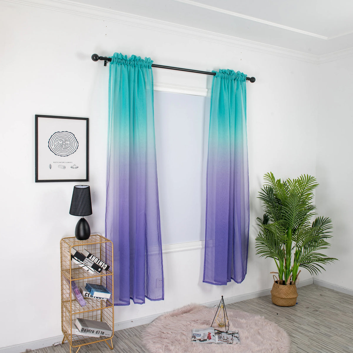 Voilage dégradé turquoise et violet installé sur une tringle noire dans une pièce lumineuse avec déco végétale.