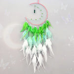 Ce captivant attrape-rêves vert et blanc, orné de plumes, de perles et d'un pendentif en pierre verte, crée une atmosphère sereine et méditative.