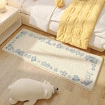 Un tapis moelleux aux motifs floraux bleus et beiges, posé sur un parquet de couleur bois clair dans une chambre élégante et cosy.