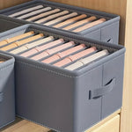 Boîte de rangement tissu verte utilisée dans un dressing organisé