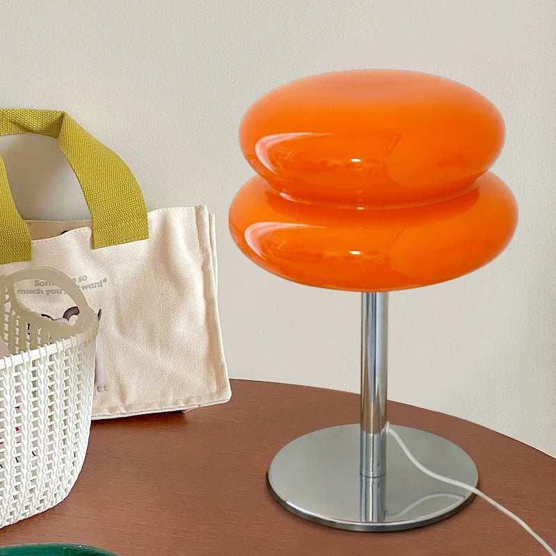 Lampe de table avec abat-jour rose éclairant une chambre à coucher