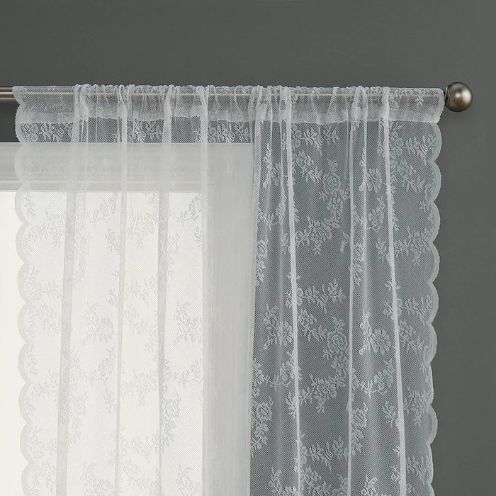 Voilage blanc transparent à motifs floraux, suspendu sur une tringle métallique.