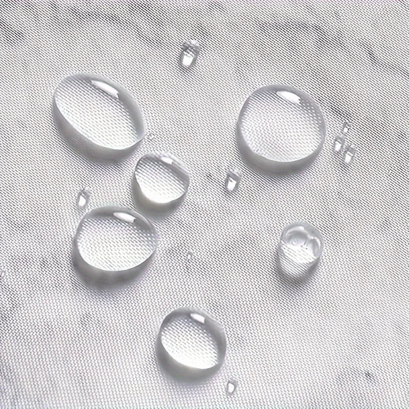 Gros plan sur un tissu imperméable avec des gouttes d'eau, illustrant l'effet déperlant du matériau utilisé pour le rideau de douche.