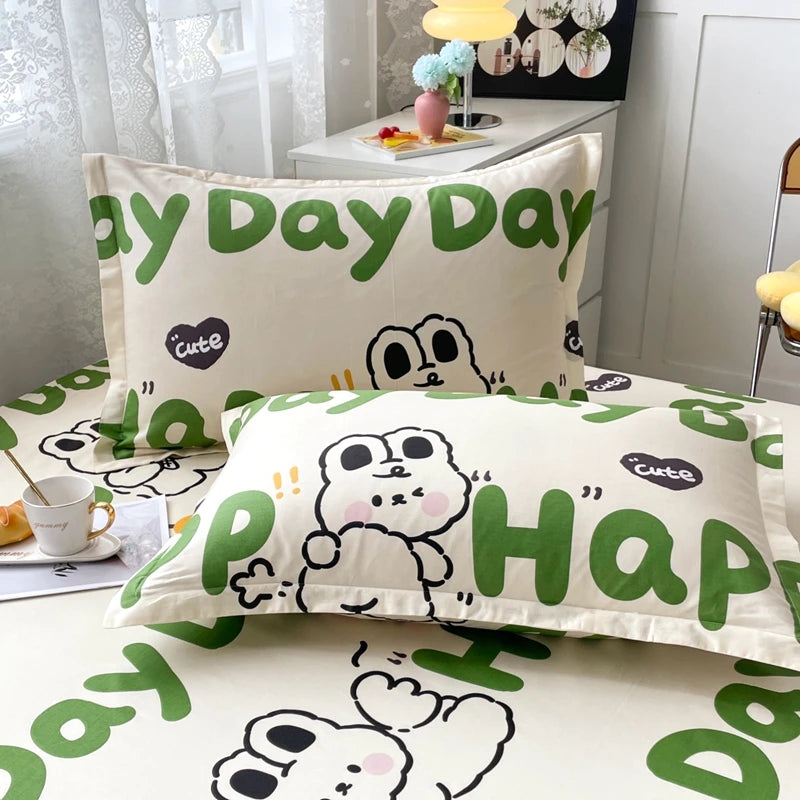 Couette et taies d'oreiller avec un motif amusant de personnages mignons et des messages joyeux, créant une ambiance douce et confortable dans la chambre.