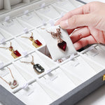 Boîte à bijoux luxe en cuir double face rouge fermée sur une coiffeuse