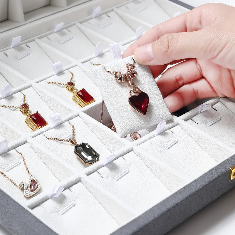 Boîte à bijoux luxe en cuir double face rouge fermée sur une coiffeuse