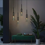 Suspension luminaire noire installée au-dessus d'une table de salle à manger