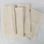 Serviettes de bain beige en tissu texturé et doux.