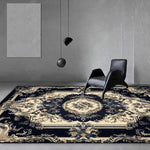 Un agencement minimaliste de meubles sombres sur un tapis orné de motifs baroques dorés, créant un contraste saisissant dans cette scène épurée.