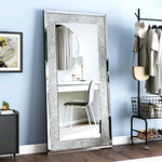 Un grand miroir encadré de métal gris et blanc, reflétant une chambre moderne avec des touches de style industriel.