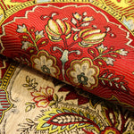 Riche motif floral en rouge et or sur un tissu ornemental.