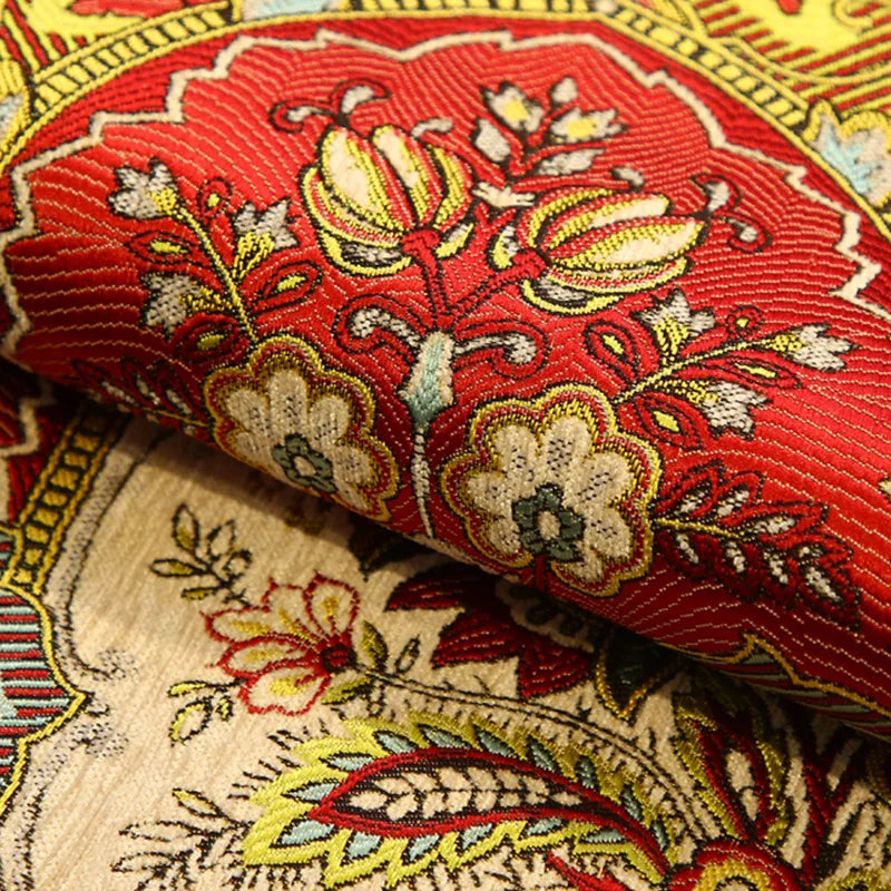 Riche motif floral en rouge et or sur un tissu ornemental.