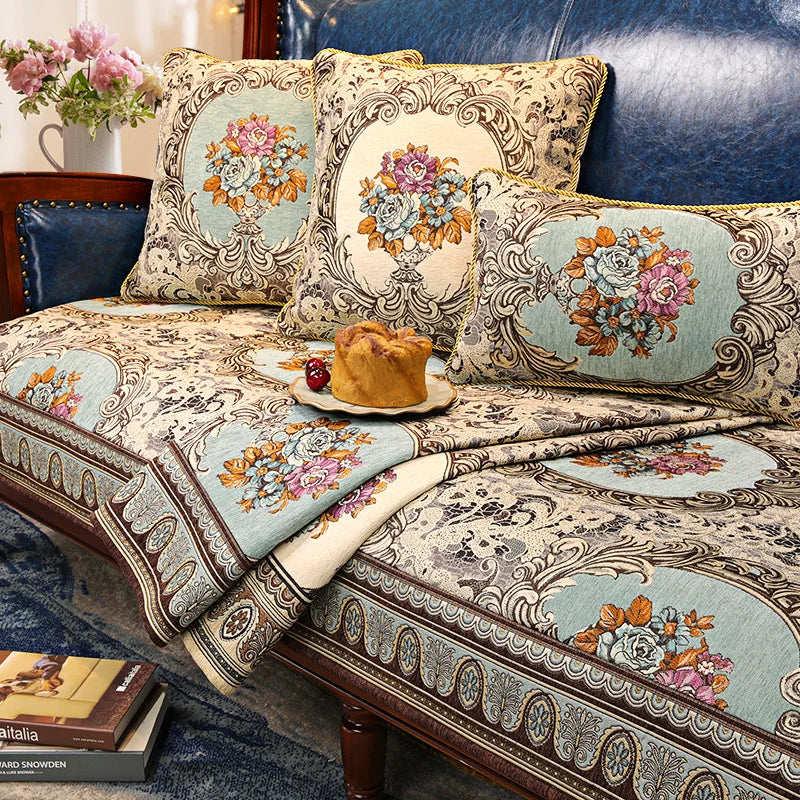Des coussins décoratifs élégants, aux motifs floraux colorés et ornés de motifs décoratifs sur un canapé de style vintage, créant une atmosphère chaleureuse et accueillante dans la pièce.