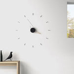 Horloge murale design minimaliste dorée sur mur blanc salon