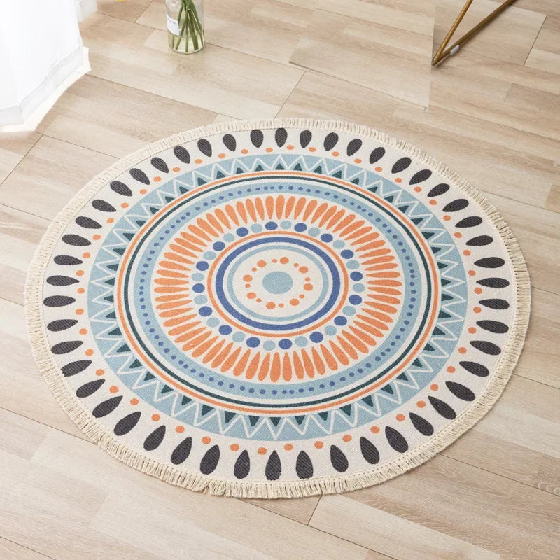 Un joli tapis rond orné d'un motif géométrique coloré aux nuances de bleu, orange et gris, créant un design captivant sur un sol en bois clair.