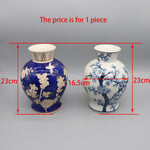 Deux vases décorés de motifs floraux et botaniques, l'un de couleur bleue et l'autre blanc avec un motif de fleurs de cerisier.