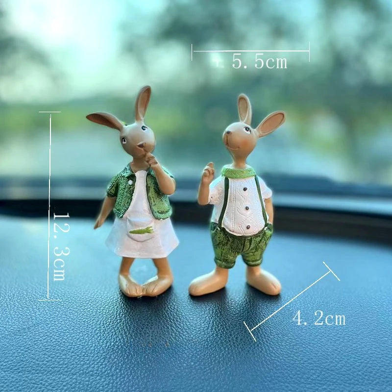 Deux figurines de lapins mignons portant des vêtements verts, posées sur une surface sombre, avec leurs dimensions indiquées.
