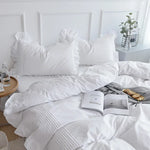 Parure de lit en coton et lin blanc avec volants sur un lit
