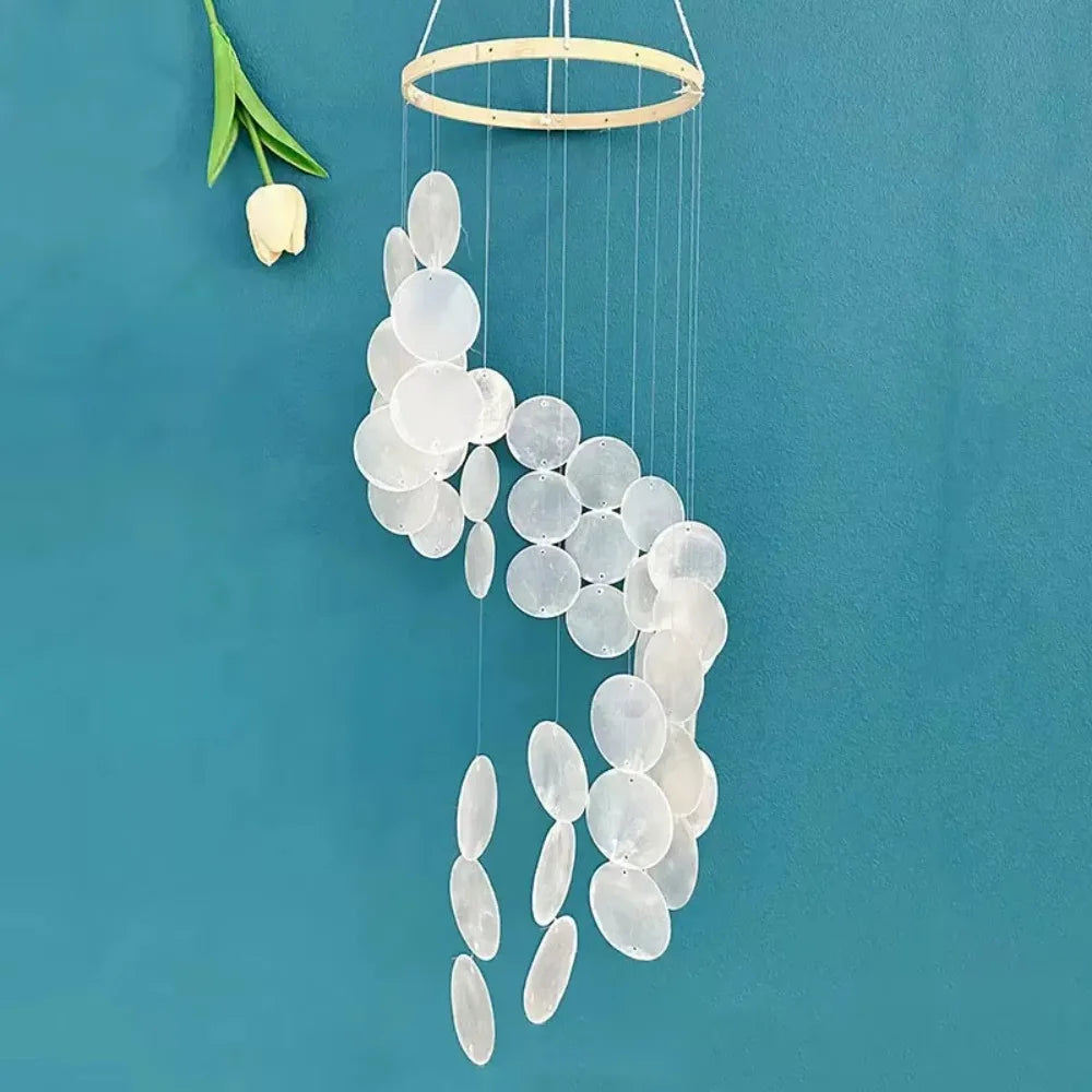 Carillon éolien en coquille naturelle suspendu dans une chambre moderne