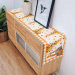 La console en bois avec des motifs de feuilles d'automne et une décoration de fleurs crée une ambiance chaleureuse et accueillante dans cette pièce.