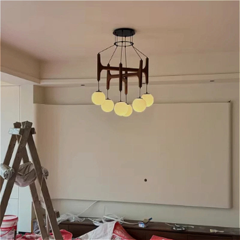 Lustre LED géométrique en bois crème suspendu dans une chambre parentale