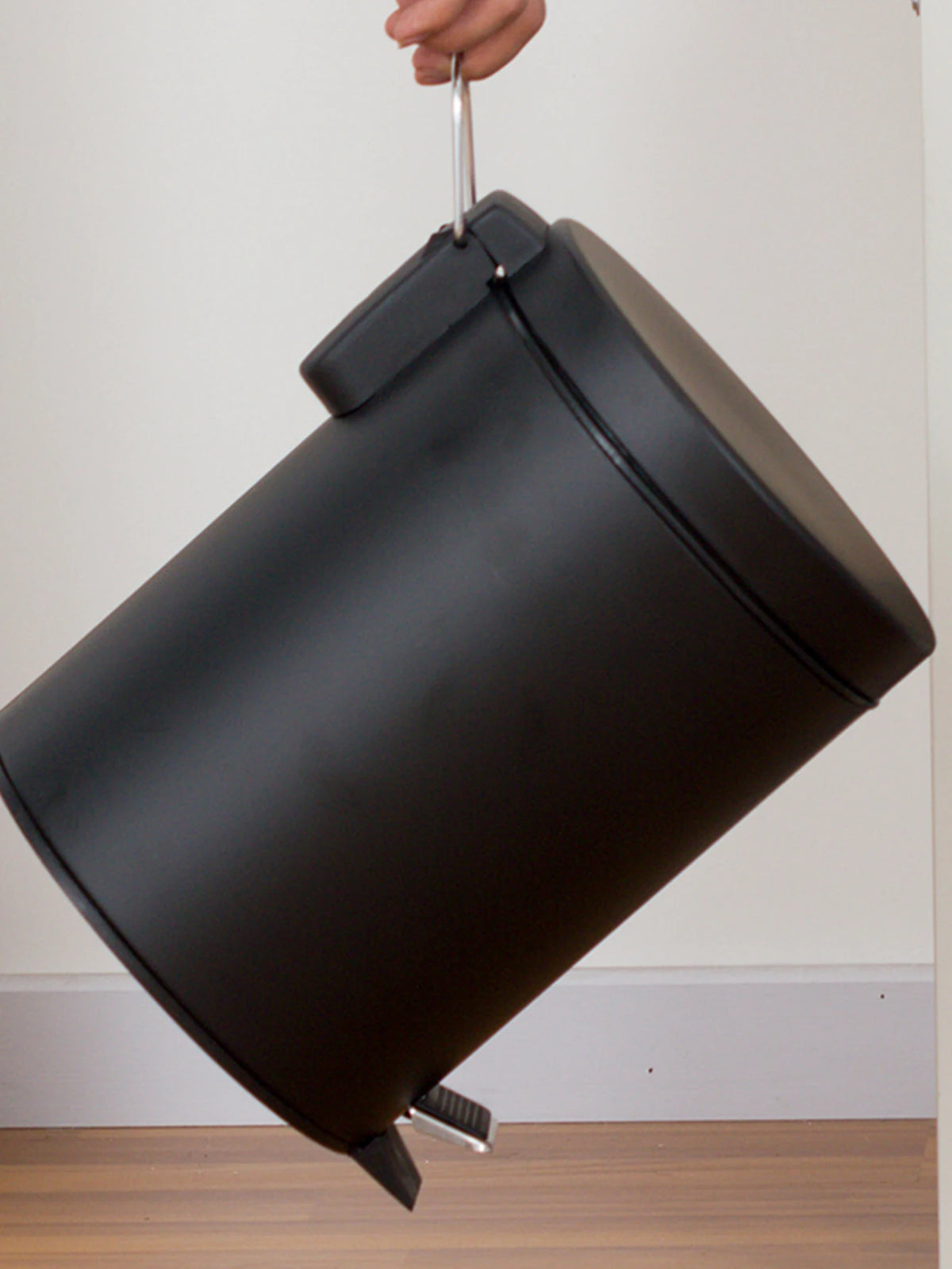 Mini poubelle noire compacte placée sous un lavabo