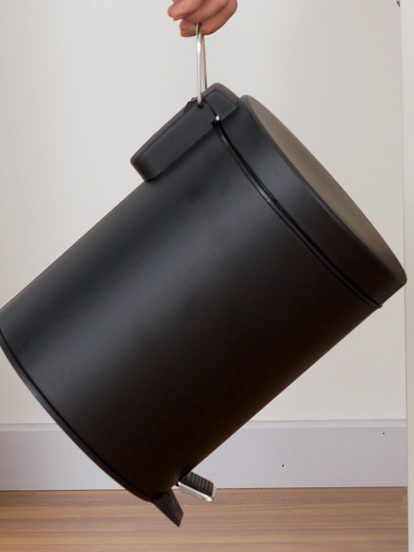 Mini poubelle noire compacte placée sous un lavabo
