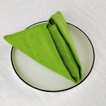 Un torchon vert vif posé sur un miroir en verre rond noir.