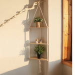 Étagère murale triangle macramé boho suspendue avec plantes vertes dans un salon