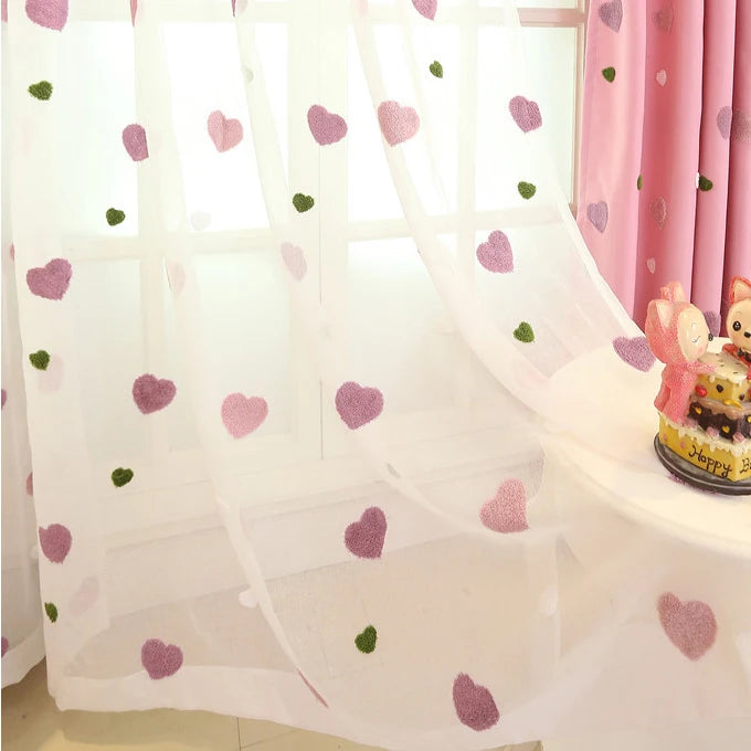 Voilage décoratif blanc avec motifs de cœurs roses et verts, idéal pour chambre d'enfant ou salon. Apporte une touche de charme et de douceur à votre intérieur tout en filtrant délicatement la lumière naturelle. Design élégant et fantaisie pour sublimer vos fenêtres. Parfait pour créer une ambiance accueillante et chaleureuse.