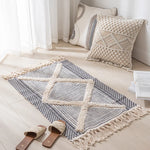 Un tapis de sol en coton et fibre naturelle dans des tons beiges et gris, avec un motif géométrique élégant, placé dans un intérieur lumineux et épuré.