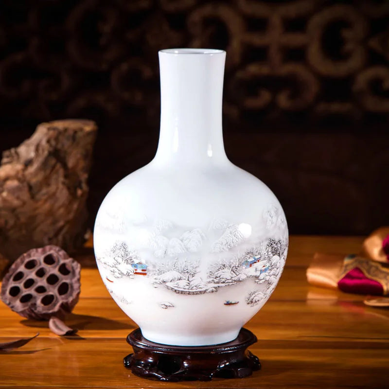 Un magnifique vase en porcelaine blanche avec un paysage d'hiver délicatement peint, posé sur un présentoir en bois sombre.