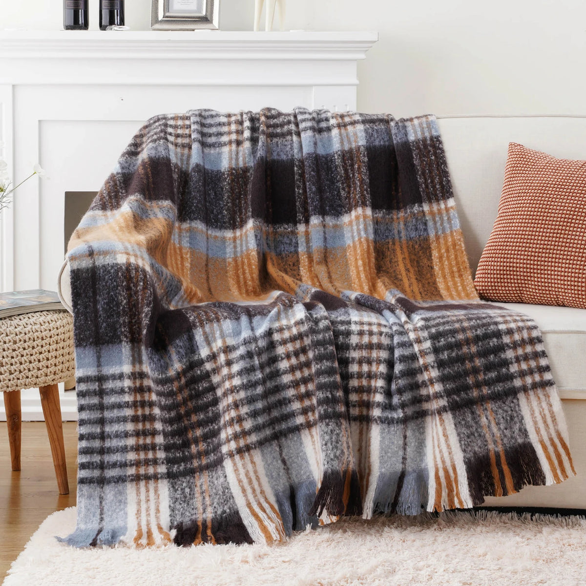 Une couverture en laine à carreaux gris, orange et blancs, parfaite pour une décoration cosy et confortable.