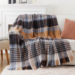 Une couverture en laine à carreaux gris, orange et blancs, parfaite pour une décoration cosy et confortable.
